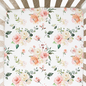 Peach floral fitted crib sheet at an angle, perfect for adding charm to your baby's nursery decor.
