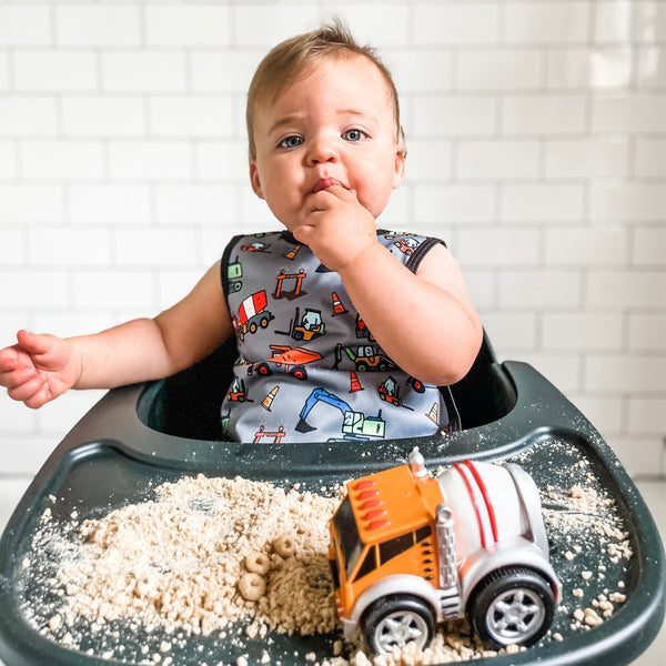 "Construction Zone Bapron for babies, featuring colorful designs and a practical, mess-free design at a 15-degree angle."