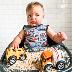 "Construction Zone Bapron for babies, featuring colorful construction-themed design, shown from angle 2."