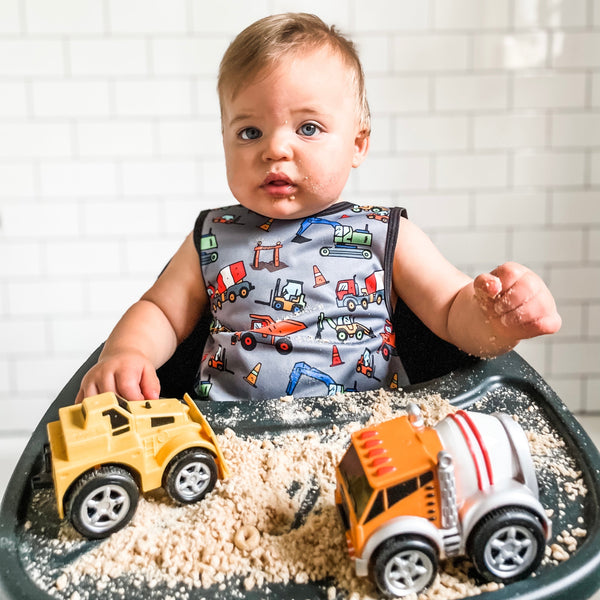 "Construction Zone Bapron for babies, featuring colorful construction-themed design, shown from angle 2."