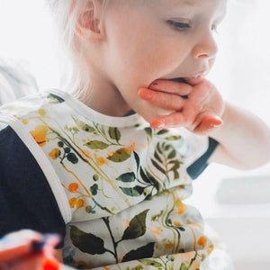 "Autumn Leaves Bapron for babies, featuring a vibrant leaf design, angled view showcasing its stylish and functional design."