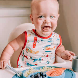 Retro Airplanes Bapron for babies, angle view showcasing playful design and practical use for mealtime messes.