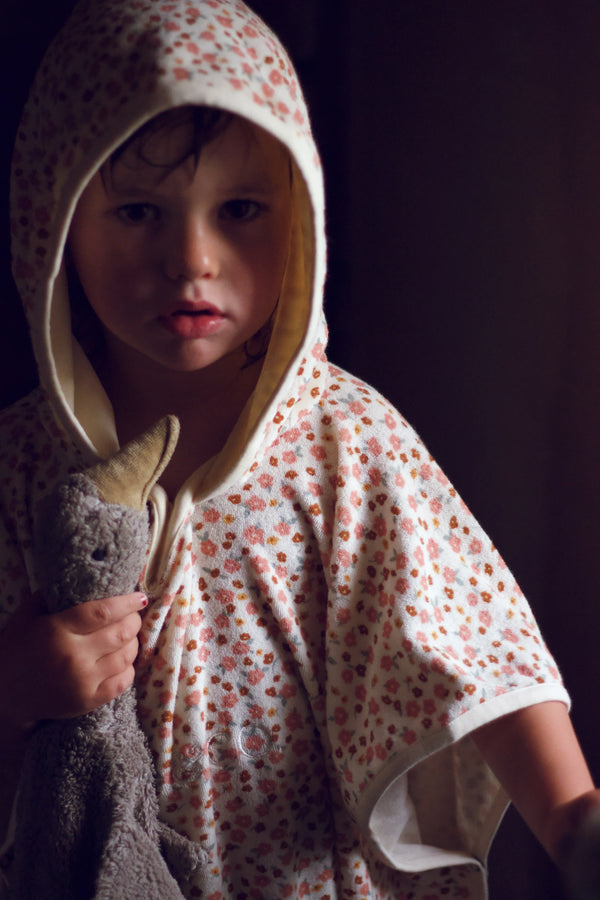 Organic cotton bathing towel poncho for babies in Sunset Meadow design, angled view showcasing softness and style.