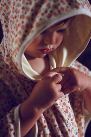 Organic cotton bathing towel poncho in Sunset Meadow design, angle view, perfect for babies after bath time.