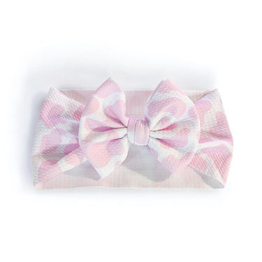 Pink cow spots baby headwrap bow, perfect for stylish infants. Ideal accessory for hats, socks, and mittens collection.