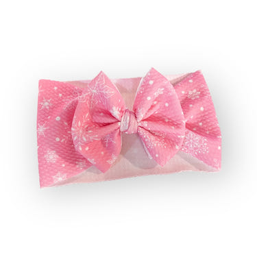 Pink snowflake headwrap bow for babies, perfect accessory for winter outfits.