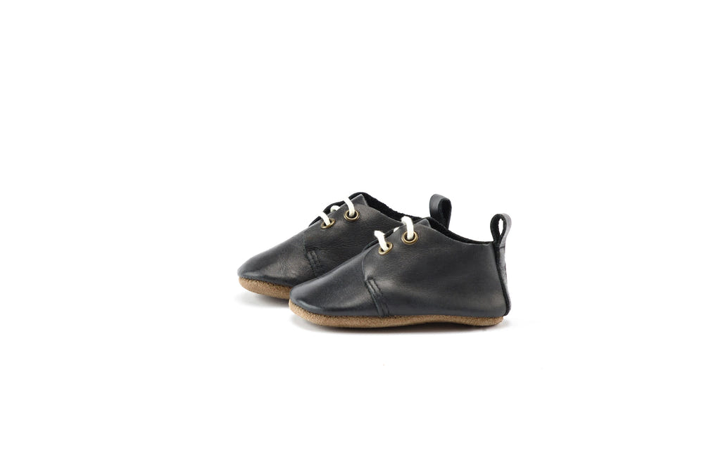 Black low top oxfords for babies with soft sole, perfect for stylish and comfortable first steps.