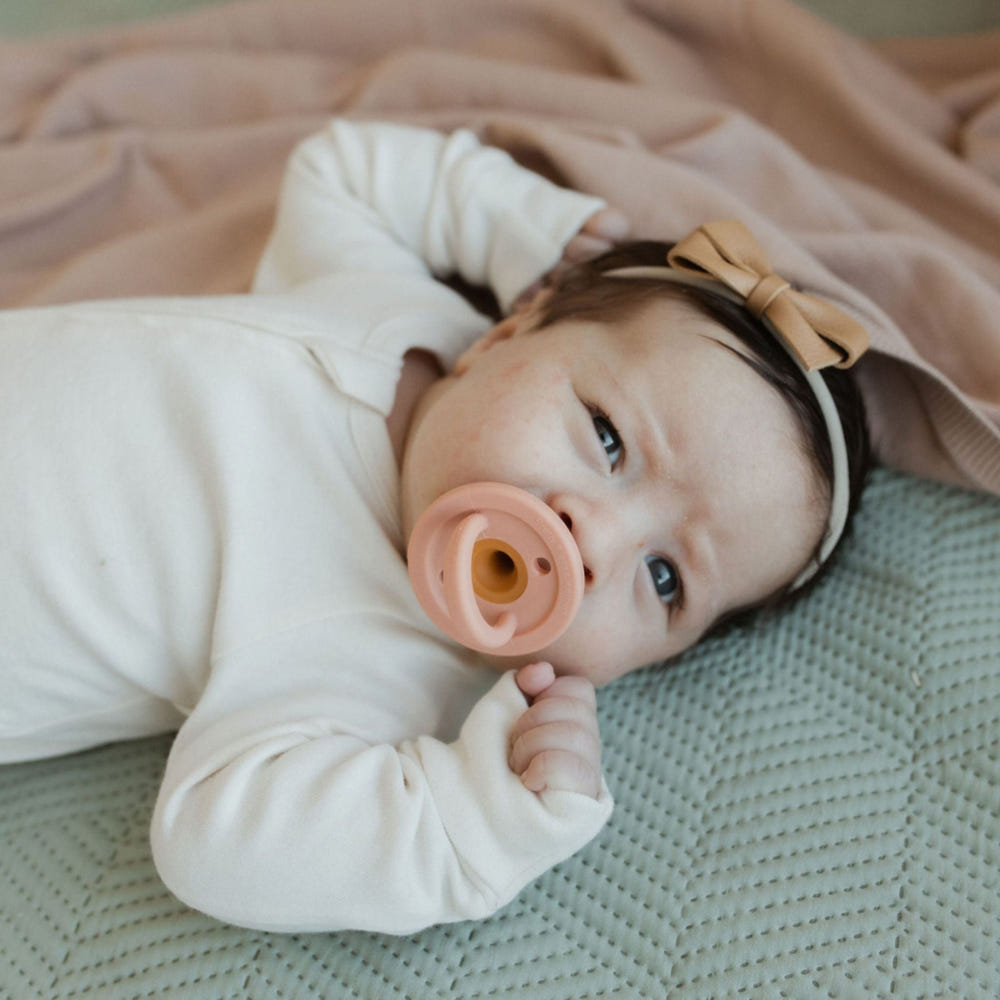 Modern speckled almond pacifier for babies, designed for comfort and style.