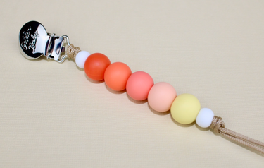 Sunrise Pacifier Clip in vibrant colors, perfect for keeping pacifiers secure and stylish for your baby.