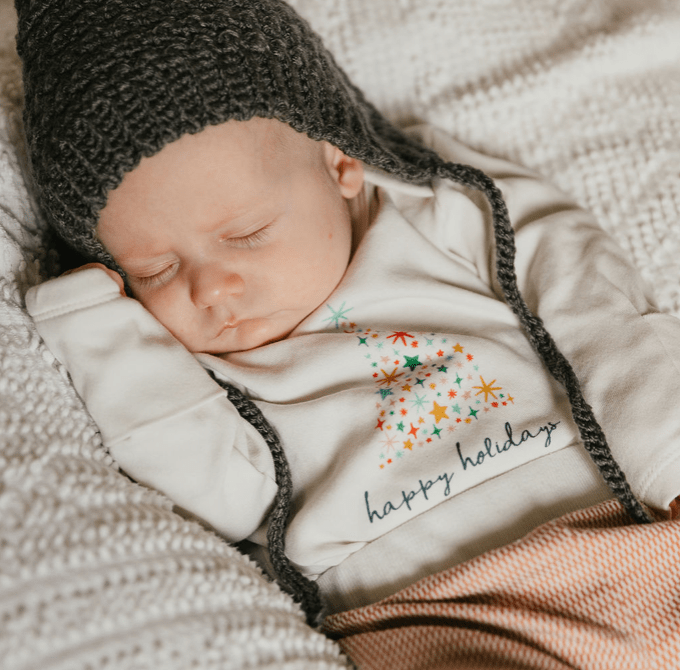 Long sleeve graphic bodysuit featuring a festive happy holidays tree design for babies.