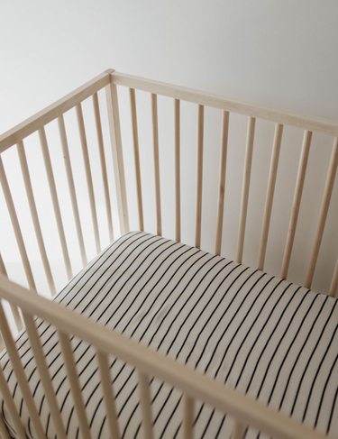 Grey and black striped muslin crib sheet for stylish and comfortable baby bedding.
