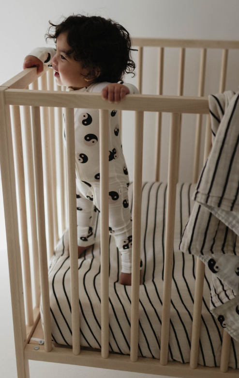 Grey and black striped muslin crib sheet for stylish and comfortable baby bedding.