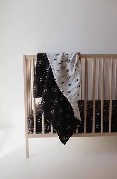 Muslin quilt in charcoal with smile and white bolt design, perfect for babies. Soft and stylish blanket for swaddling.