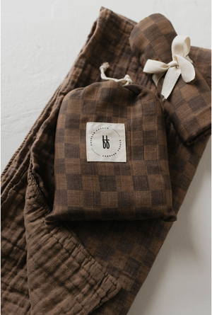 Faded brown checkerboard muslin quilt for babies, angled view showcasing soft texture and cozy design.