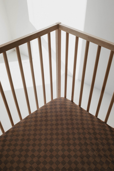 Faded brown checkerboard muslin crib sheet for cozy and stylish baby bedding.