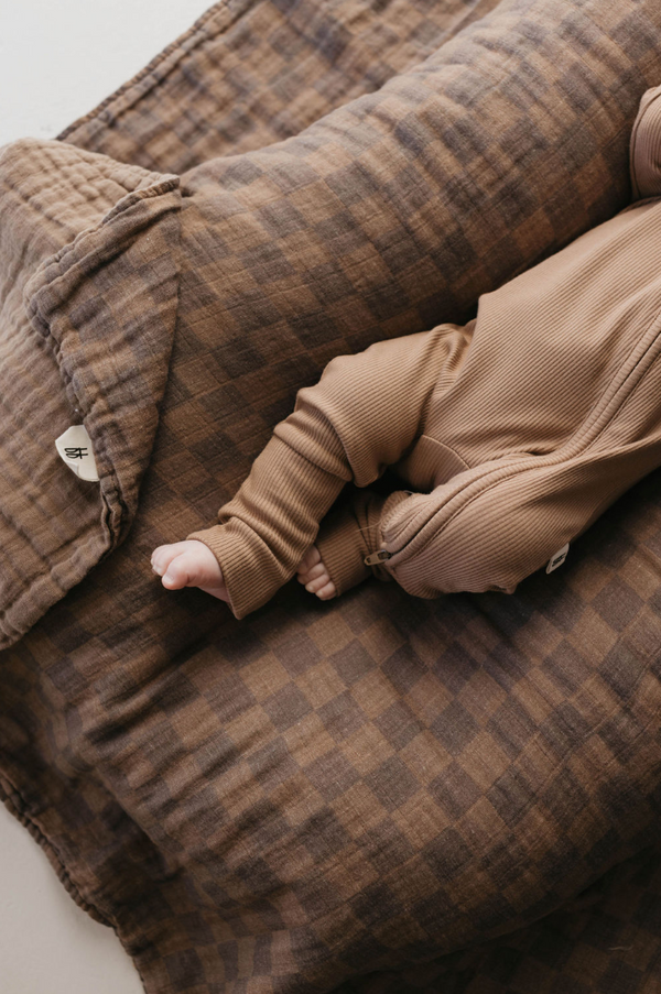 Faded brown checkerboard muslin quilt for babies, showcasing soft texture and cozy design from angle 4.