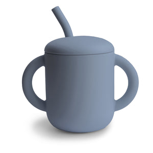 Silicone training cup with straw for babies, angled view showcasing its ergonomic design and vibrant colors.