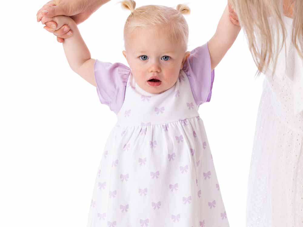 Organic cotton Alice ruffled dress with bow for babies and toddlers, perfect for special occasions.