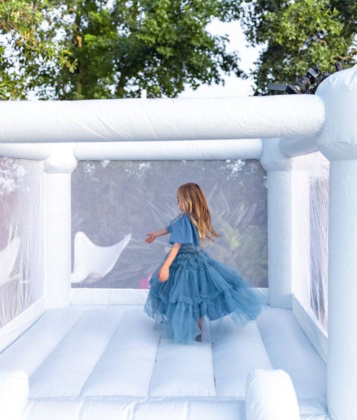 Mini Leo Muted Blue Bounce House at an angle, perfect for outdoor playsets and fun for toddlers.