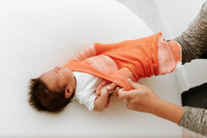 Orange Swaddle Sleep Sack from Swaddelini, shown at angle 5, perfect for cozy and safe baby sleep.