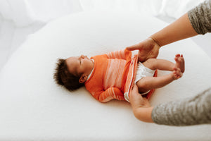 Orange Swaddle Sleep Sack from Swaddelini, cozy and stylish for peaceful baby sleep. Angle 4 view.