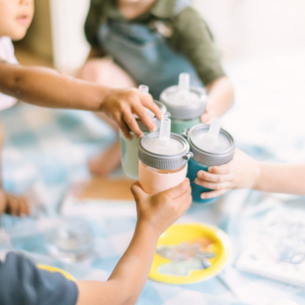 Silicone sleeve 2 pack for baby cups, providing grip and protection, angled view showcasing vibrant colors and design.