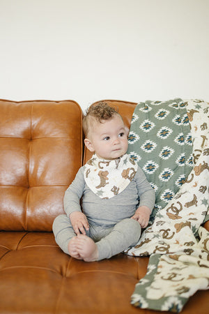 Outlaw Cowboy Classic Muslin Bib for babies, featuring a stylish cowboy design, shown at an angle.