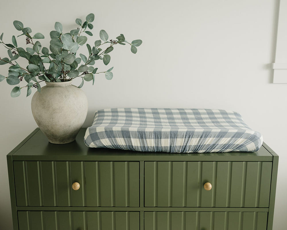 Dusty blue gingham muslin changing pad cover for stylish and comfortable diaper changes.