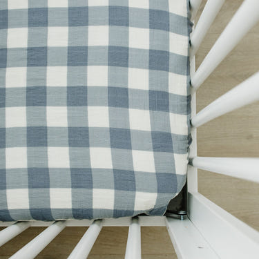 Dusty blue gingham muslin crib sheet for stylish and comfortable baby bedding.