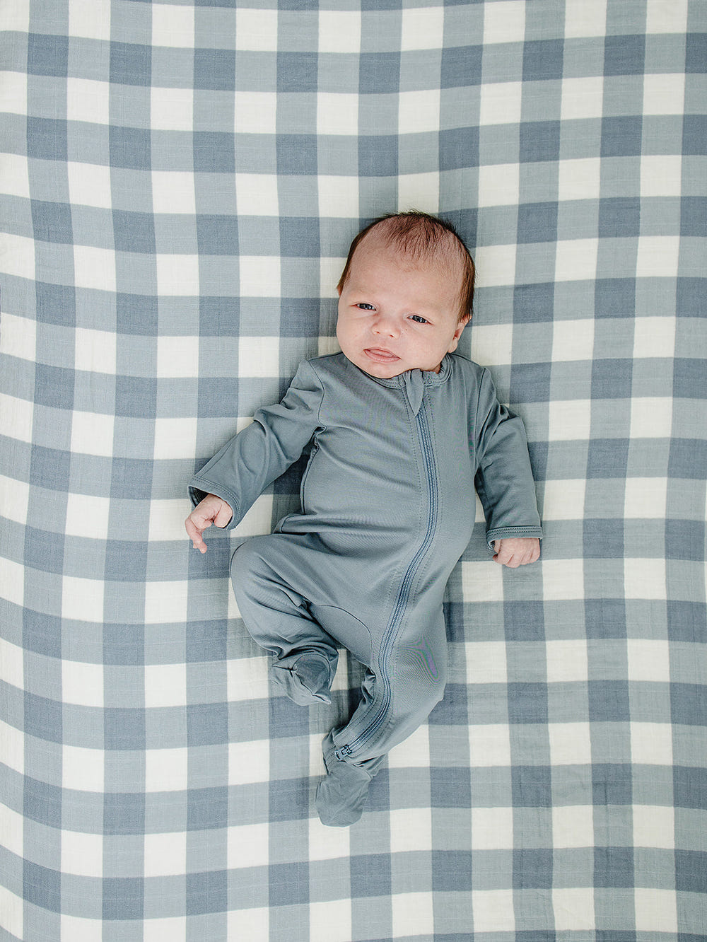 Dusty blue gingham muslin crib sheet for stylish and comfortable baby bedding.