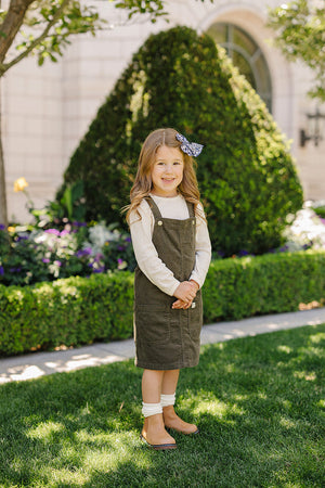 Green corduroy dress for babies, angle view showcasing soft fabric and stylish design. Perfect for any occasion.