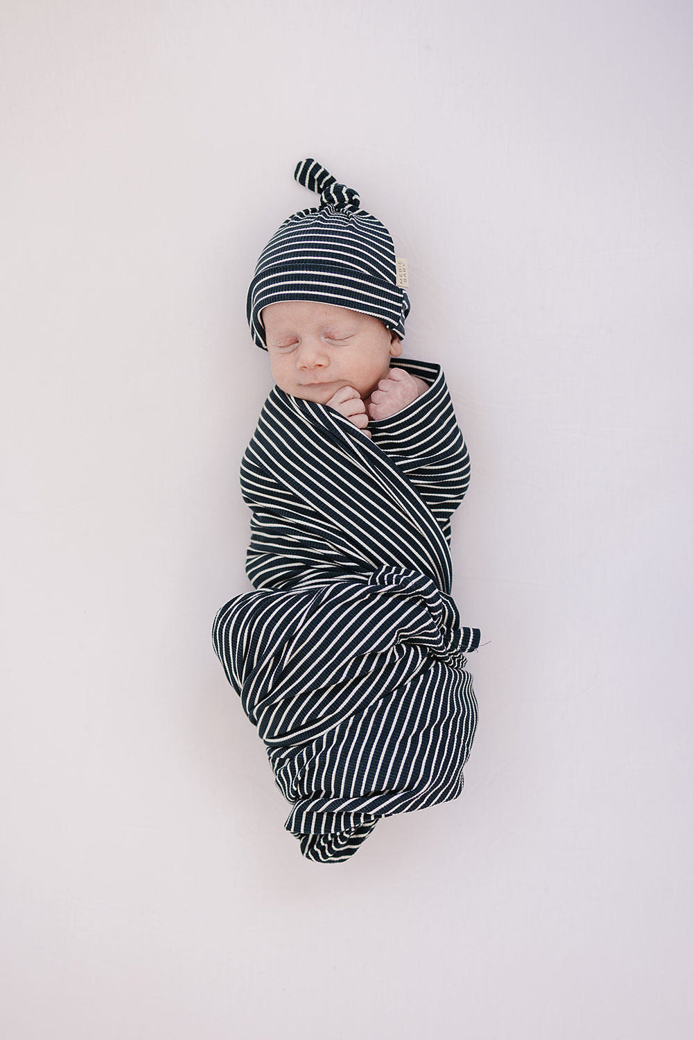 Navy stripes ribbed bamboo stretch swaddle for babies, perfect for comfortable sleep and cozy bedding.