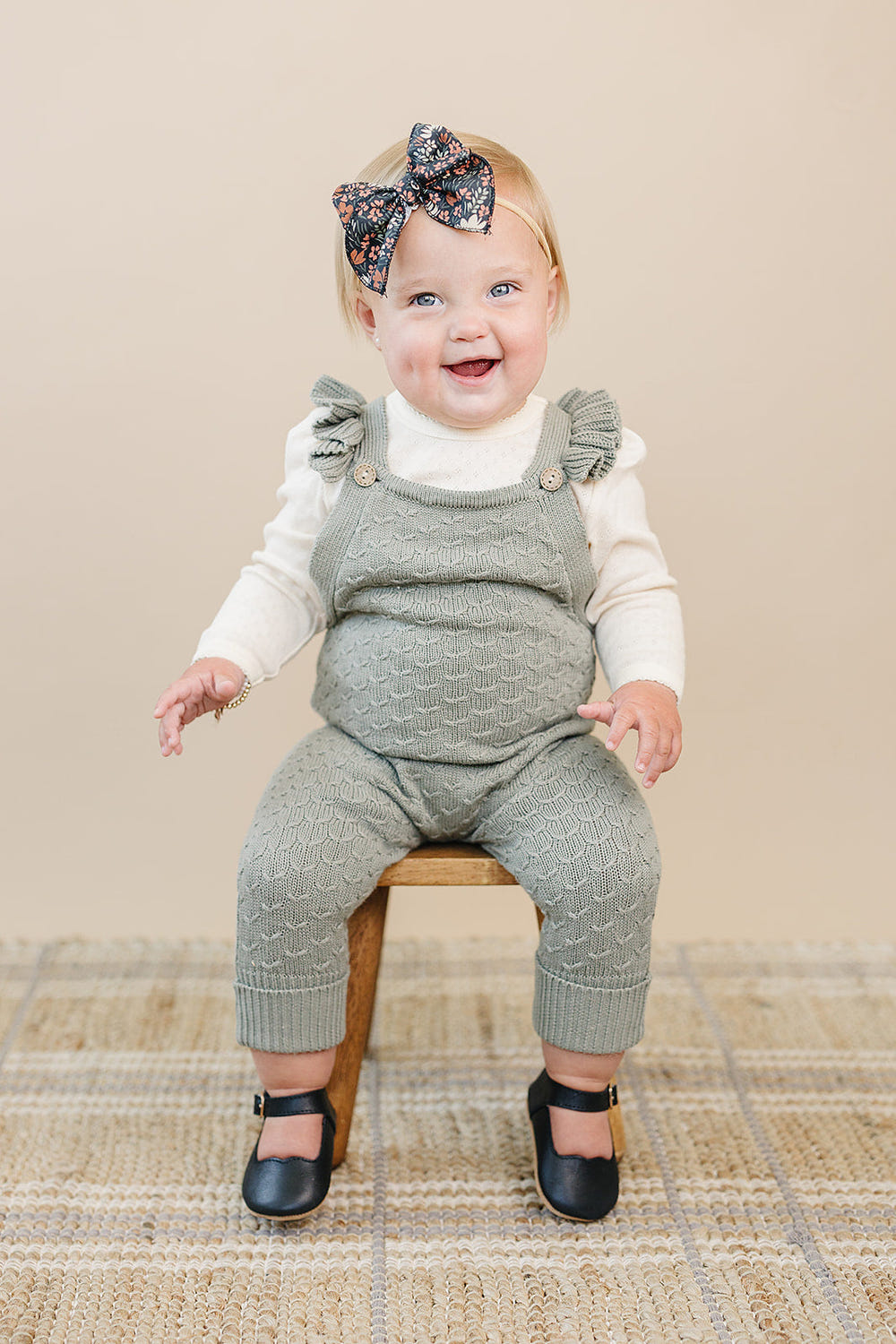 Green ruffle knit overalls for babies, perfect for stylish and comfortable playtime.