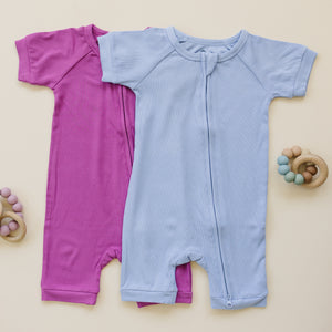 Solid ribbed bamboo shorty romper in various colors, angled view showcasing soft fabric and stylish design for babies.