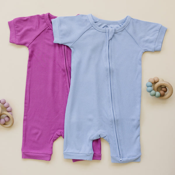 Solid ribbed bamboo shorty romper in various colors, angled view showcasing soft fabric and stylish design for babies.