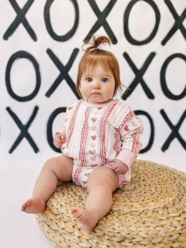 Laced with Love Sweatshirt Romper for babies, showcasing cozy style and comfort in a trendy design.