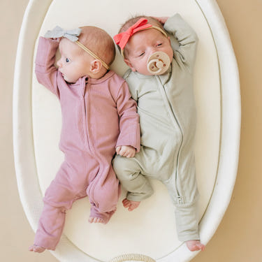 Solid ribbed bamboo zippy romper in various colors for babies, perfect for comfort and style.