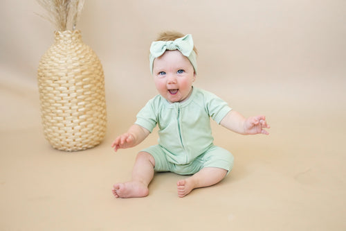 Solid ribbed bamboo shorty romper in various colors, displayed at angle 4. Ideal for stylish baby outfits.