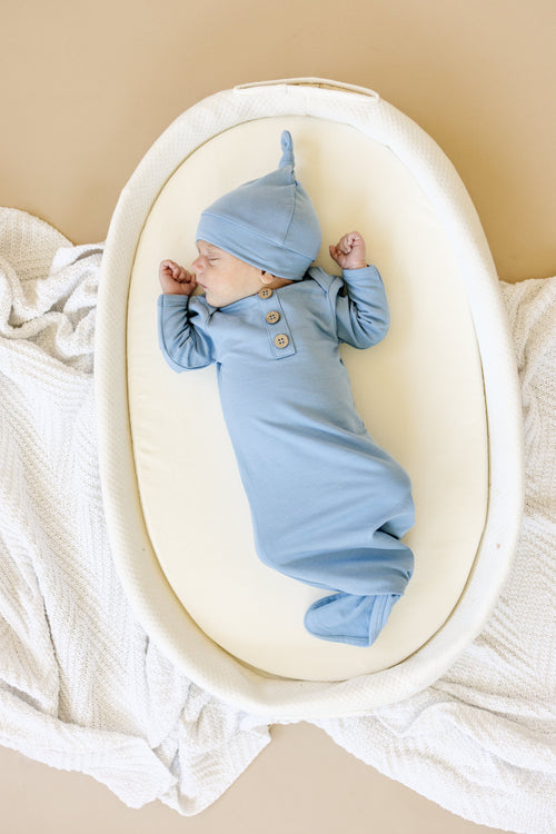 Newborn bamboo gown and hat set, soft and breathable, perfect for swaddling and comfort.