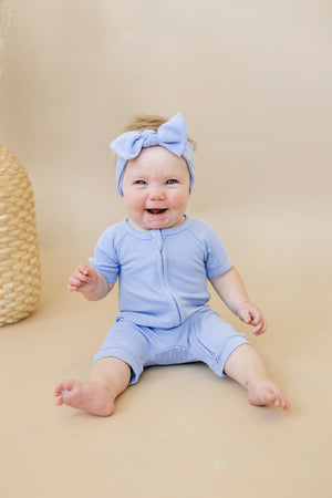Solid ribbed bamboo shorty romper in various colors, angle view showcasing soft fabric and stylish design for babies.