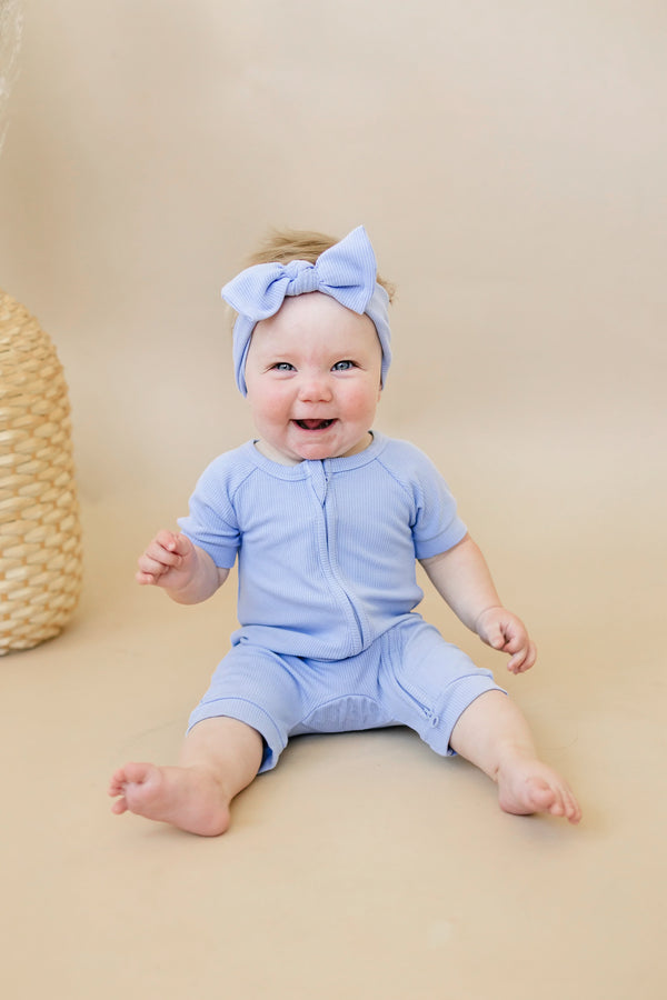 Solid ribbed bamboo shorty romper in various colors, angle view showcasing soft fabric and stylish design for babies.