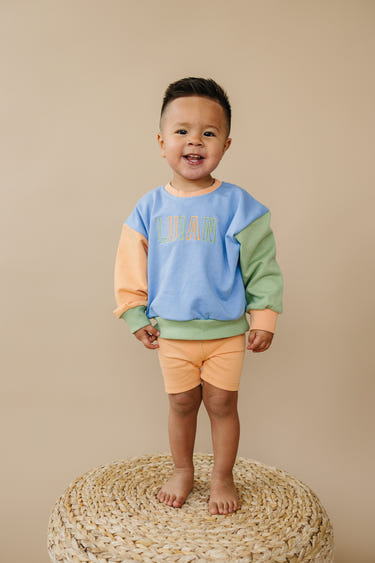 Orange ribbed bike shorts for babies, perfect for comfort and style during playtime.