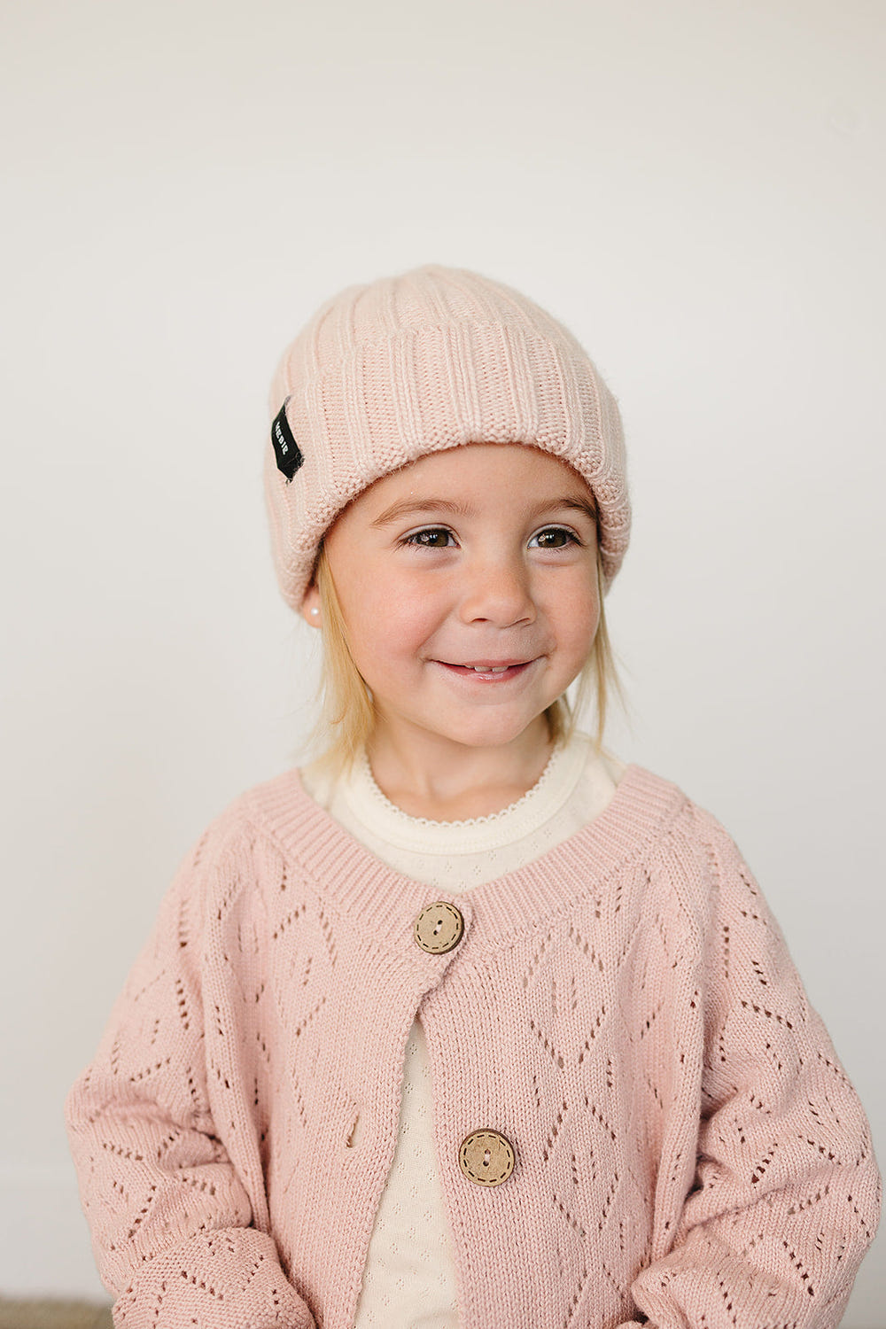 Light pink chunky knit beanie for babies, perfect for warmth and style in cooler weather.