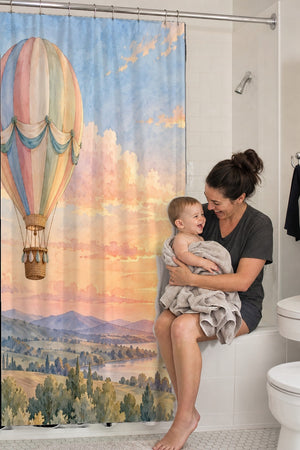 Mom holding her baby on the tub edge next to the Sunset Flight Hot Air Balloon shower curtain