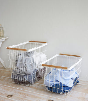 Wire basket in two sizes, featuring steel and wood design, perfect for laundry organization. Angle view 4.