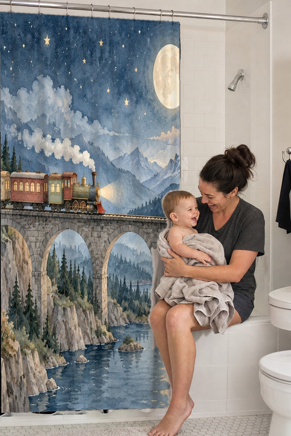 Mom holding her baby on the tub edge next to the Moonlit Train shower curtain