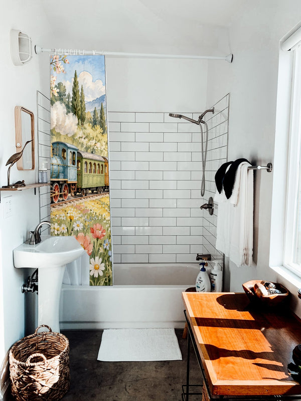 Flower Meadow Train shower curtain hanging on the rod over a white bathtub