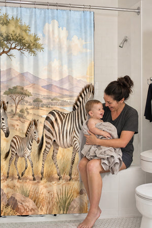 Mom holding her baby on the tub edge next to the Zebra Family Safari shower curtain