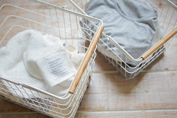 Wire basket in two sizes, featuring steel and wood design, ideal for laundry organization.