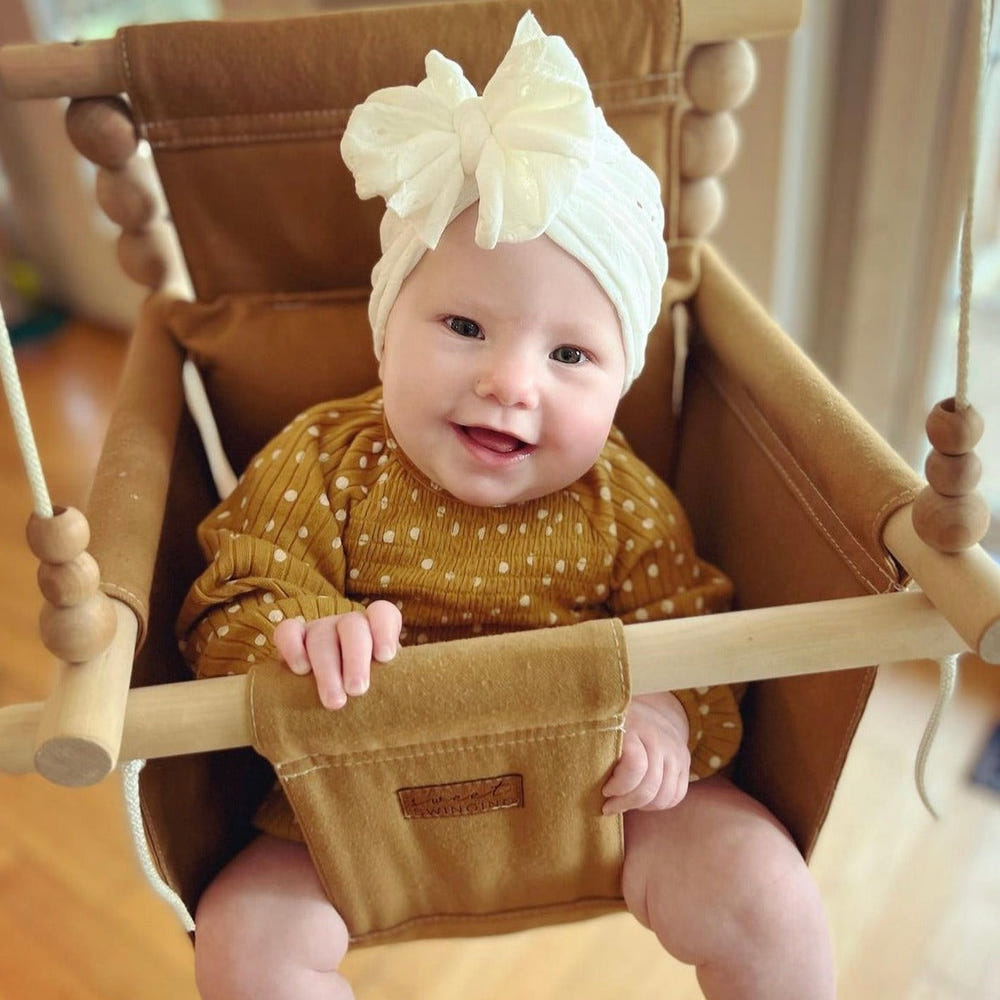Nutmeg indoor baby swing in a cozy design, perfect for soothing and entertaining infants at home.